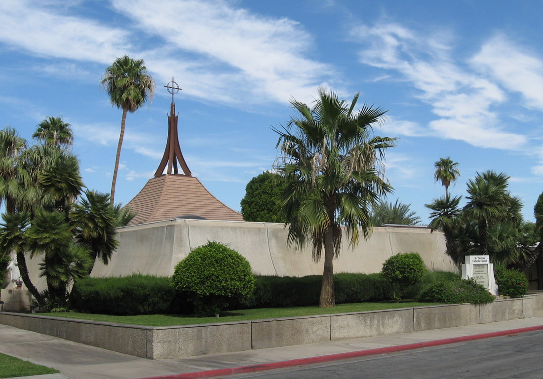 Front corner view of St. Theresa's Church in Palm Springs with blue cloudy sky and greenery